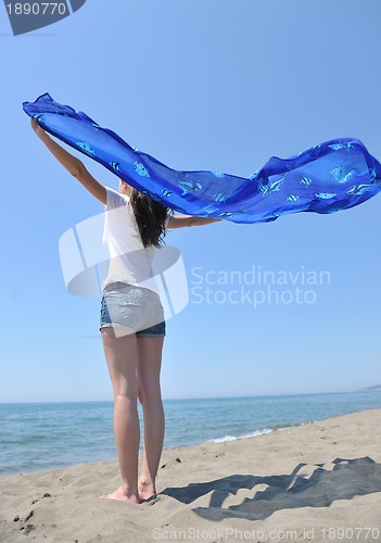 Image of beautiful young woman on beach with scarf