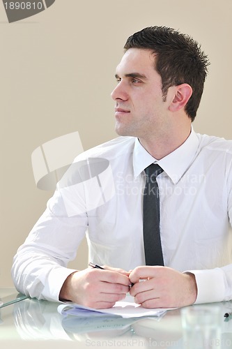 Image of young business man alone in conference room