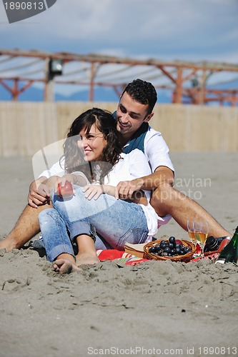 Image of young couple enjoying  picnic on the beach