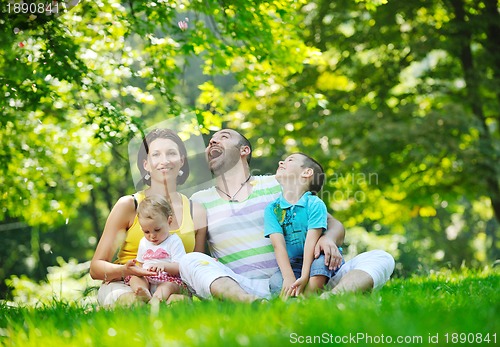 Image of happy young couple with their children have fun at park