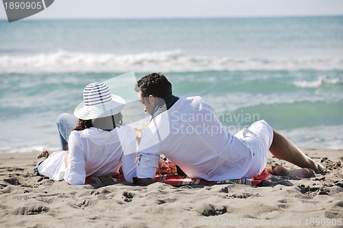 Image of young couple enjoying  picnic on the beach