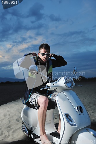 Image of young man ride retro scooter