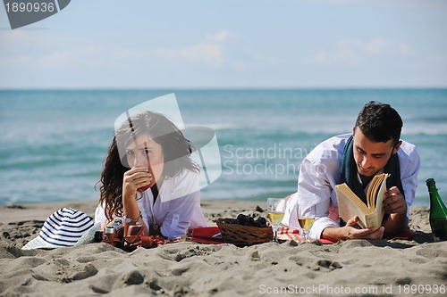 Image of young couple enjoying  picnic on the beach