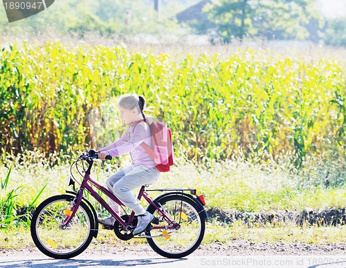 Image of schoolgirl traveling to school on bicycle