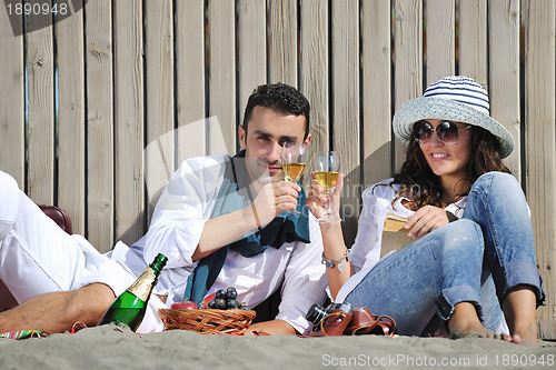 Image of young couple enjoying  picnic on the beach
