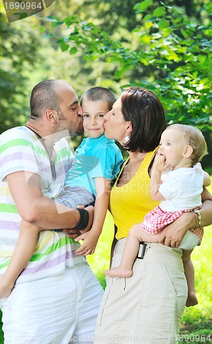 Image of happy young couple with their children have fun at park