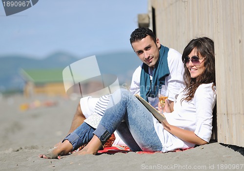 Image of young couple enjoying  picnic on the beach
