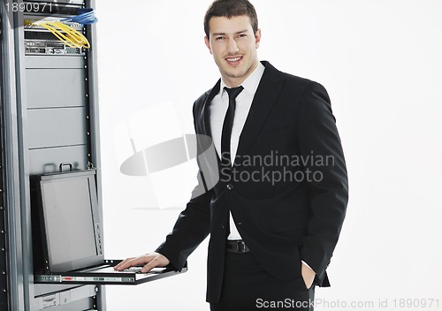 Image of businessman with laptop in network server room