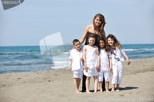 Image of group portrait of childrens with teacher on beach