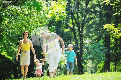 Image of happy young couple with their children have fun at park