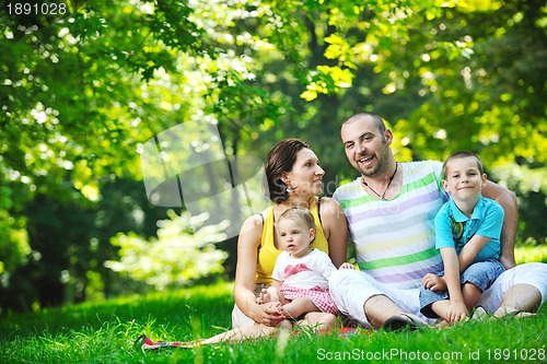 Image of happy young couple with their children have fun at park