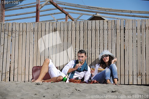 Image of young couple enjoying  picnic on the beach