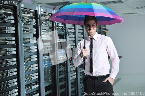 Image of businessman hold umbrella in server room