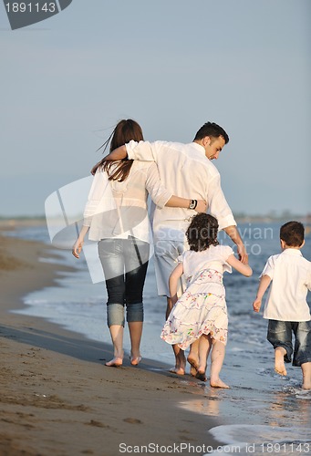 Image of happy young family have fun on beach at sunset