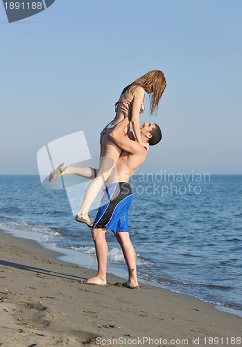 Image of happy young couple have romantic time on beach