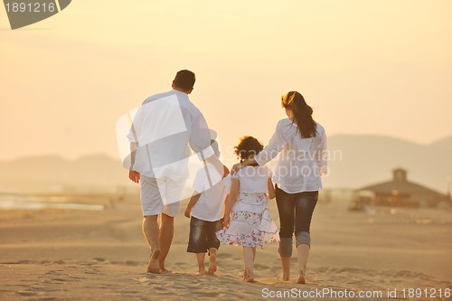 Image of happy young family have fun on beach at sunset