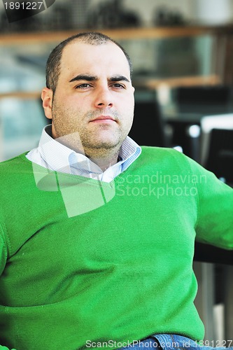 Image of young business man alone in conference room