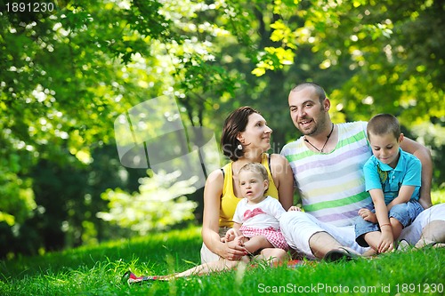 Image of happy young couple with their children have fun at park