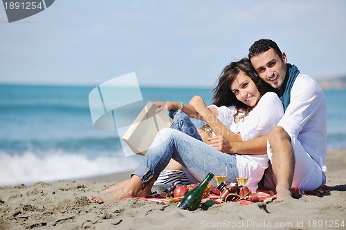 Image of young couple enjoying  picnic on the beach
