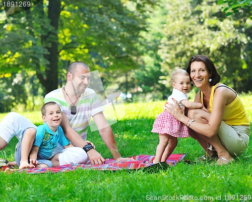 Image of happy young couple with their children have fun at park