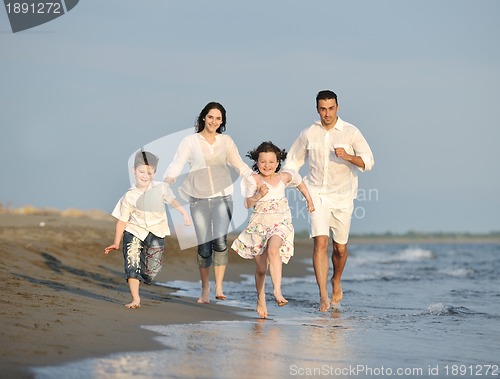 Image of happy young family have fun on beach at sunset