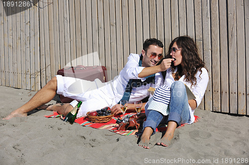 Image of young couple enjoying  picnic on the beach