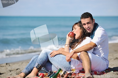 Image of young couple enjoying  picnic on the beach