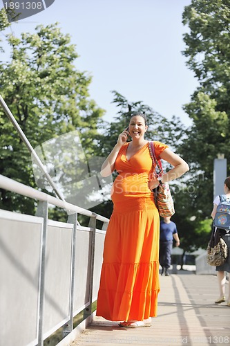 Image of happy pregnant woman talking by cellphone