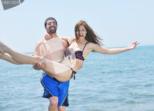 Image of happy young couple have romantic time on beach