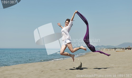 Image of beautiful young woman on beach with scarf