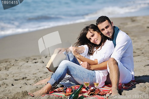 Image of young couple enjoying  picnic on the beach