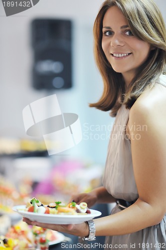 Image of womanl chooses tasty meal in buffet at hotel