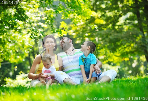 Image of happy young couple with their children have fun at park