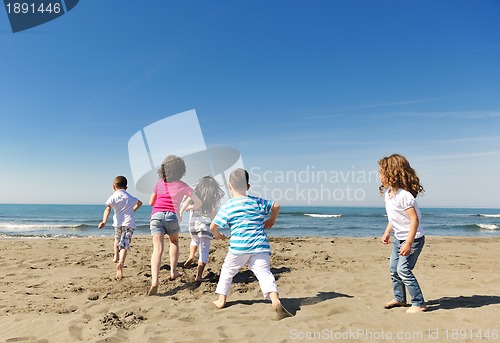 Image of happy child group playing  on beach