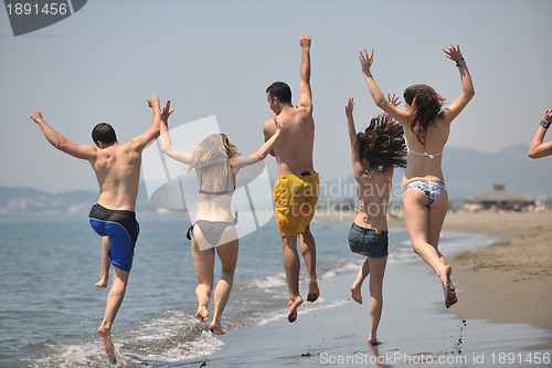 Image of happy people group have fun and running on beach