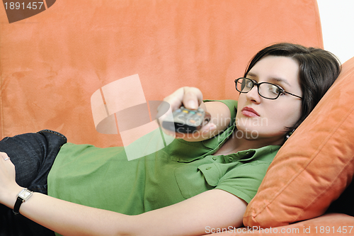 Image of happy woman relax on orange sofa