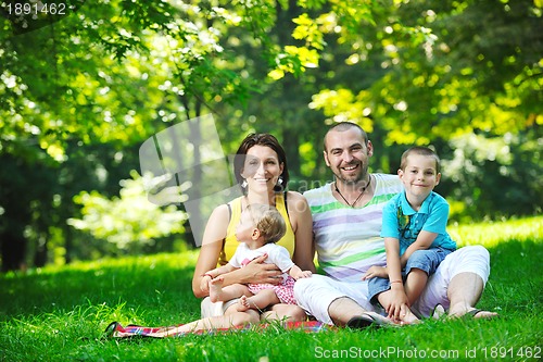 Image of happy young couple with their children have fun at park