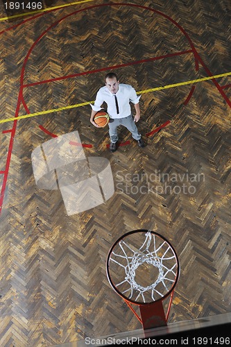 Image of businessman holding basketball ball