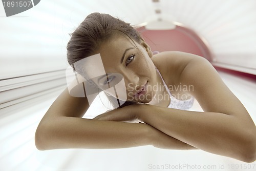 Image of Beautiful young woman tanning in solarium