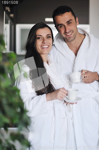 Image of Young love couple taking fresh morning cup of coffee