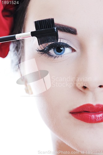 Image of beautiful young woman applying makeup