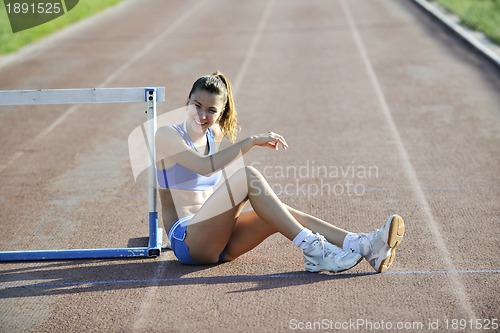 Image of happy young woman on athletic race track