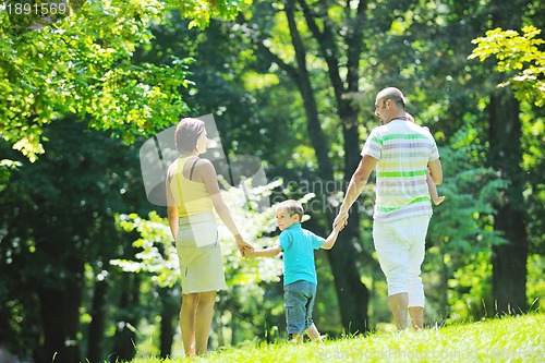 Image of happy young couple with their children have fun at park