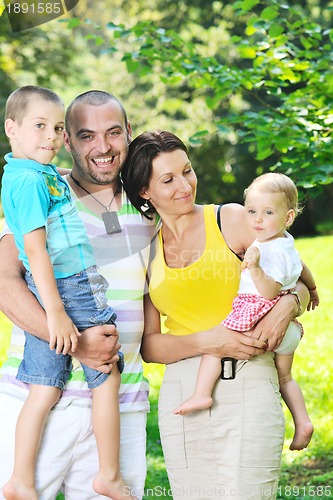Image of happy young couple with their children have fun at park