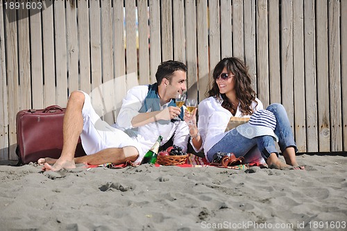 Image of young couple enjoying  picnic on the beach