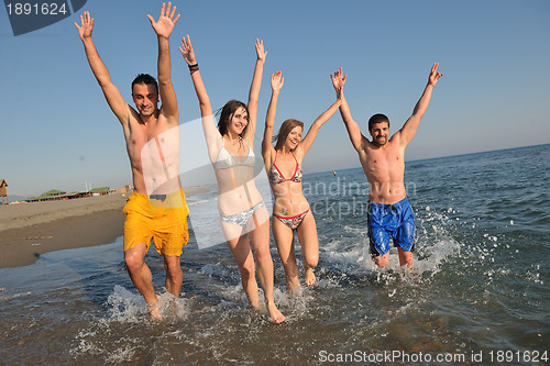 Image of happy people group have fun and running on beach