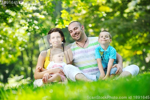 Image of happy young couple with their children have fun at park