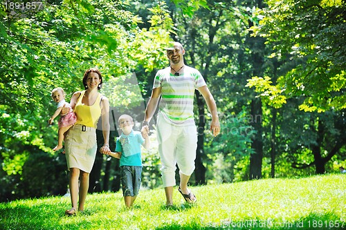 Image of happy young couple with their children have fun at park