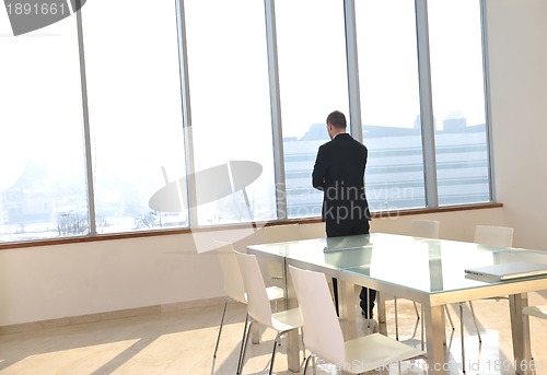 Image of young business man alone in conference room
