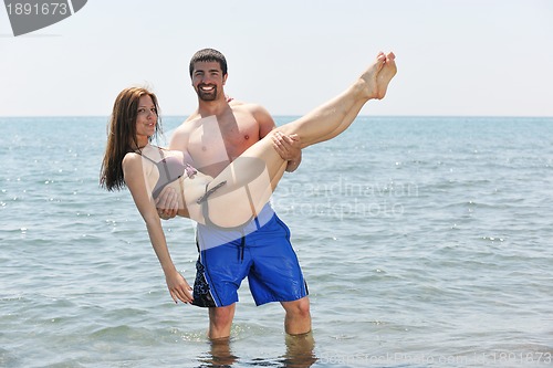 Image of happy young couple have fun on beach
